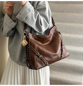 Detail view of deep brown vintage tote bag with contrast stitching and silver buckle accent