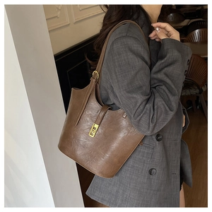 Brown vintage tote bag styled with a grey plaid blazer in a cozy cafe setting
