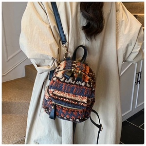 Détail du mini sac à dos en peluche tricolore avec bretelles noires et finitions dorées