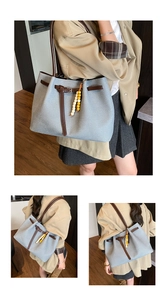 Detail view of light blue canvas tote bag with brown PU leather handles and bead charm