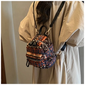 Vue détaillée d'un mini sac à dos en peluche léopard sur un trench-coat beige