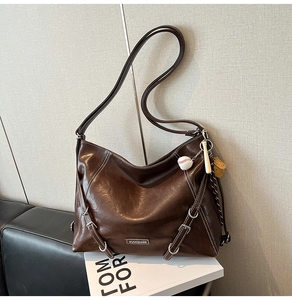Detail of dark brown faux leather tote with white contrast stitching and baseball charm