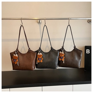 Three large matte leather tote bags in brown and grey with bear charm detailing