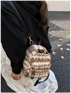 Photo en extérieur d'un mini sac à dos en peluche à motifs ondulés et zips dorés