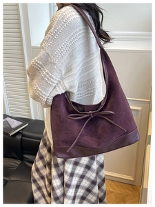 Detail view of burgundy suede tote bag featuring elegant bow design and textured finish