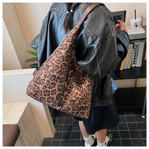 Detailed back view of a large leopard print tote bag styled in a modern urban setting
