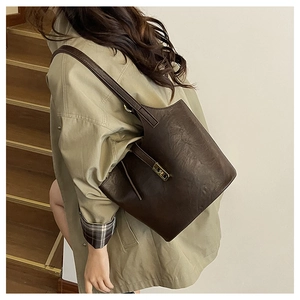Detailed texture of dark brown PU leather tote bag with elegant gold buckle