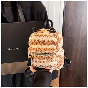 Détail d'un mini sac à dos en peluche avec motifs ondulés marron et blanc et un nœud noir