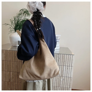 Detail of the soft khaki suede texture and wide strap on this spacious tote bag