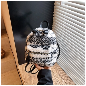 Gros plan du mini sac à dos en peluche géométrique noir et blanc avec un nœud en cuir