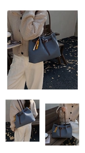 Close-up of blue tote bag with fine leather texture and colorful wooden bead charm
