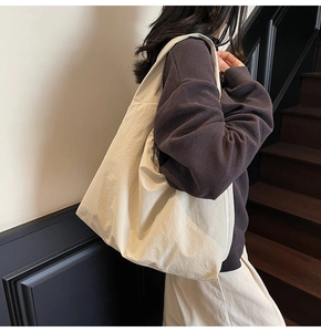 Vue détaillée du grand sac fourre-tout crème avec texture souple et design épuré