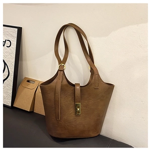 Detail of dark brown leather tote bag with vintage golden metal rotating buckle