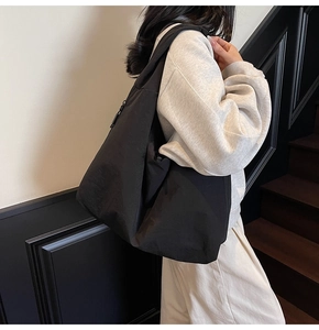 Vue détaillée du grand sac cabas en nylon noir avec fermeture éclair et design épuré