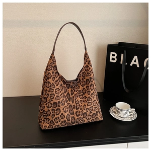 Detail shot of oversized leopard print hobo bag with slim dark brown leather shoulder strap