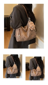 Detail of vintage brown tote bag featuring side zipper and cute plush bear charm accessory