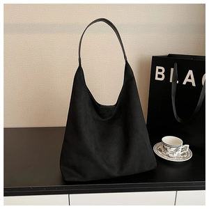 Detail view of large black suede hobo bag with smooth leather straps for women