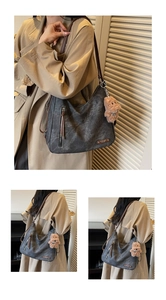 Detailed view of gray canvas tote with leather straps and bear charm accessory