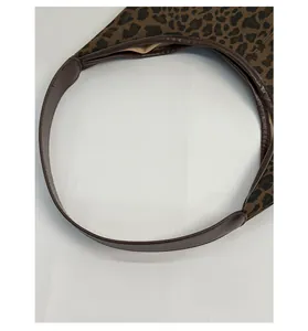 Close-up of leopard print tote bag featuring premium brown leather handle and stitching