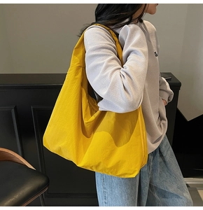 Détail d'un grand sac cabas jaune vif avec plis naturels et large bandoulière souple