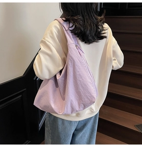 Détail du sac à bandoulière croissant violet clair avec texture en nylon plissé élégant