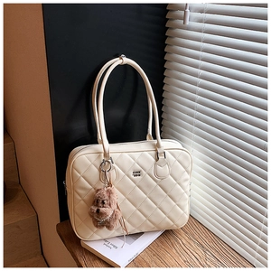 Detail of off-white quilted tote bag with a brown plush bear charm and COIN 'SDN logo