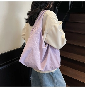 Vue arrière d'un mannequin portant un grand sac fourre-tout en nylon lilas dans l'escalier