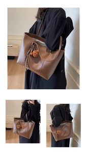Detailansichten einer großen braunen Tragetasche mit Bärenanhänger an einem Modell