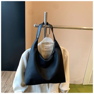 Detailed view of black matte leather tote with secure zipper and integrated shoulder strap