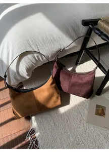 Close-up of matte suede hobo bags in vintage brown and burgundy for autumn style