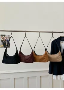 Detail view of four minimalist crescent dumpling bags in various colors on a display rack