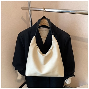 Detail view of the large off-white tote bag hanging on a rack with daily office outfits
