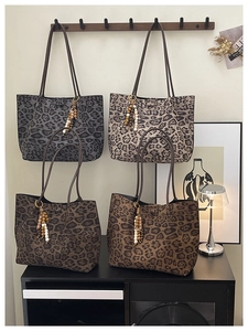 Dettaglio di borse tote leopardate in più colori con ciondoli a nappine di perline boho