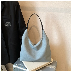 Detail of light blue woven hobo bag with sleek black leather shoulder strap and large capacity