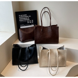 Three colors of large tote bags in pebbled faux leather with slim straps and inner pouches