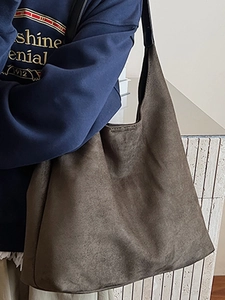 Large brown suede tote bag for women showing a stylish minimalist bucket shape in a daily use