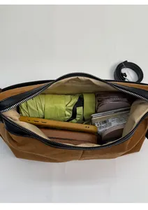 Interior view of brown suede crossbody bag showing large capacity for umbrella and phone