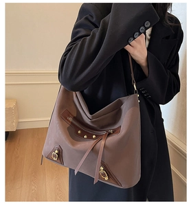 Detail view of large dark brown leather hobo bag with vintage rivets and tassel zippers