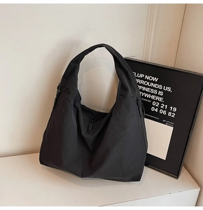 Détail du grand sac cabas noir minimaliste montrant la fermeture éclair latérale et le nylon
