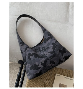 Detailed macro view of gray camouflage hobo bag with black leather shoulder strap texture
