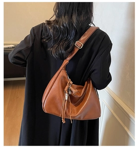 Vue détaillée du sac cabas en cuir mat maron avec cordon à franges et boucle métallique