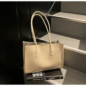Detail of cream white tote bag with vintage wrinkled leather texture on a modern background