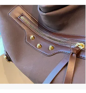 Close-up of vintage bronze studs and smooth metal zipper with long leather puller