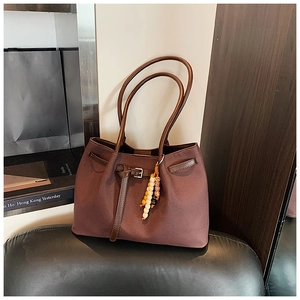Detail of dark brown tote bag with colorful wooden beads and adjustable leather strap