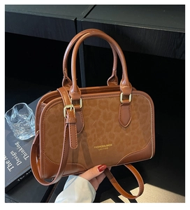 Detail of leopard print leather handbag with golden hardware and adjustable brown strap