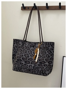 Dettaglio della grande borsa tote leopardata con cinturini marroni e nappa con perline
