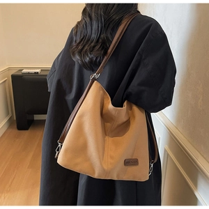 Close-up of durable khaki canvas tote bag featuring adjustable dark brown leather straps