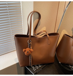 Detail einer braunen XL Shopper Tasche mit süßem Plüschbär und gestreiftem Anhänger