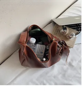 Sac hobo spacieux en cuir marron montrant sa capacité pour bouteille et cosmétiques