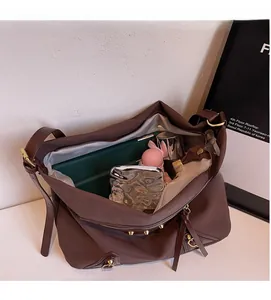 Spacious interior of a dark brown faux leather tote bag with gold metal rivet accents